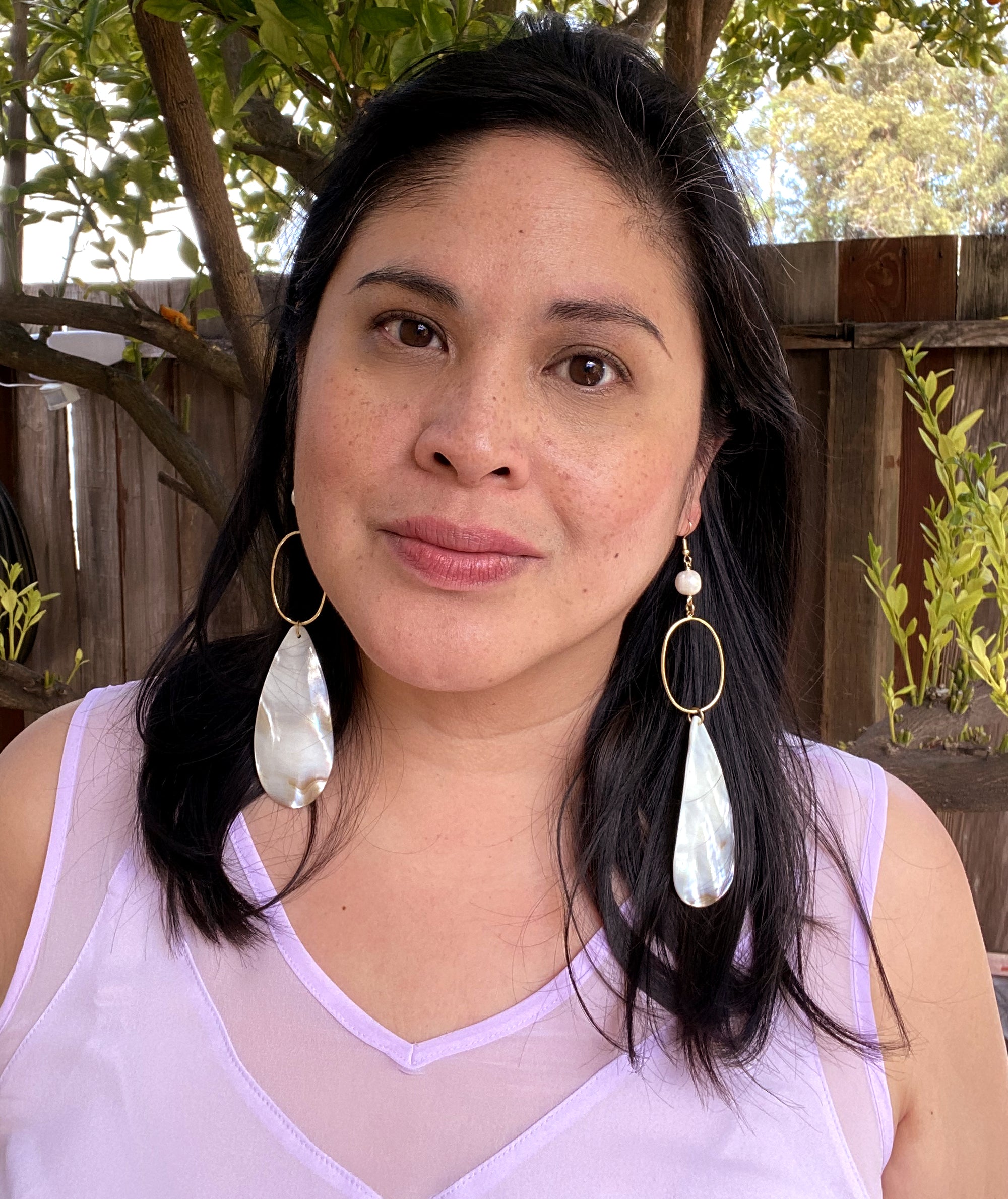 Jenny Dayco wearing shell teardrop earrings