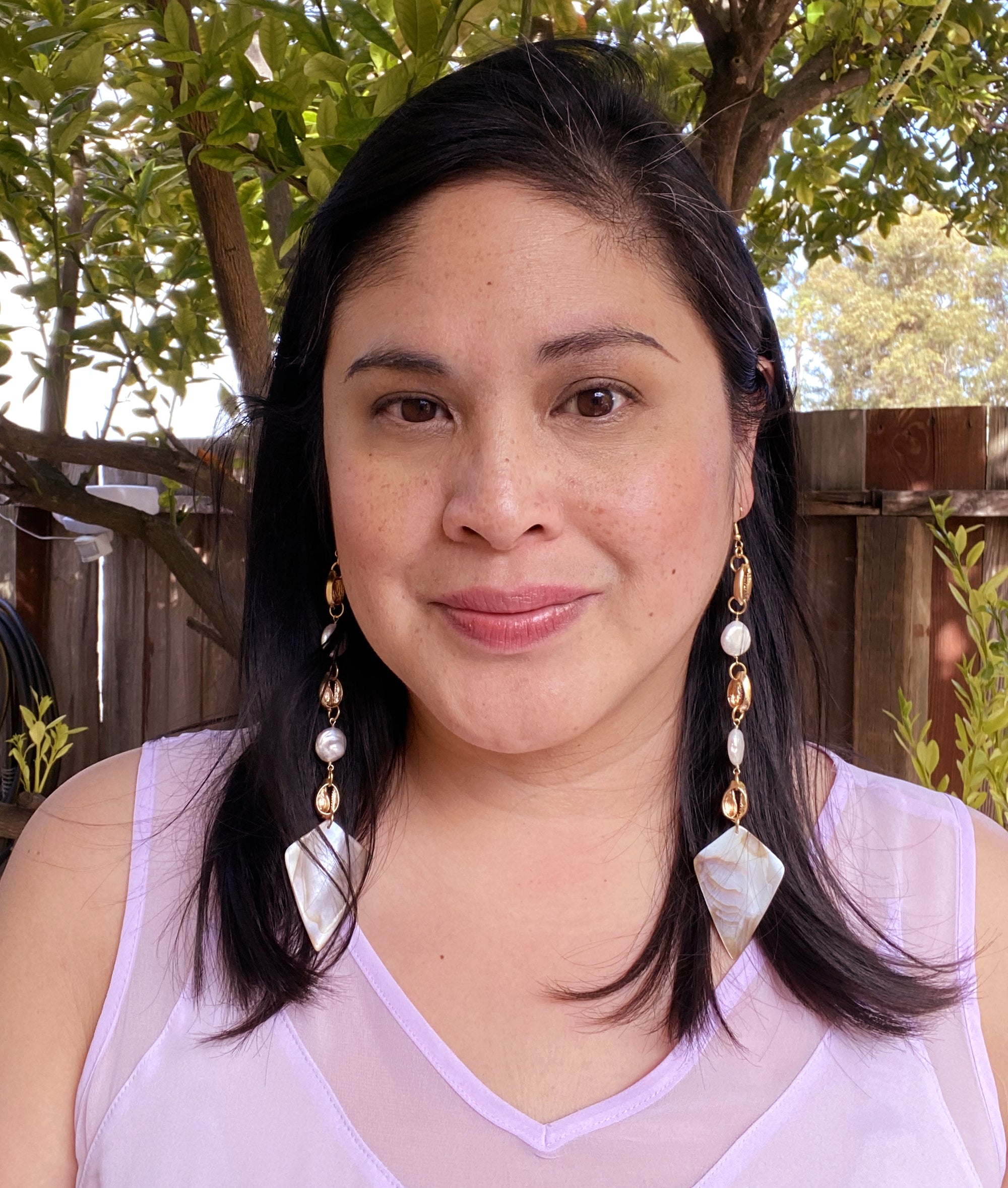 Jenny Dayco wearing cowrie shell and pearl earrings