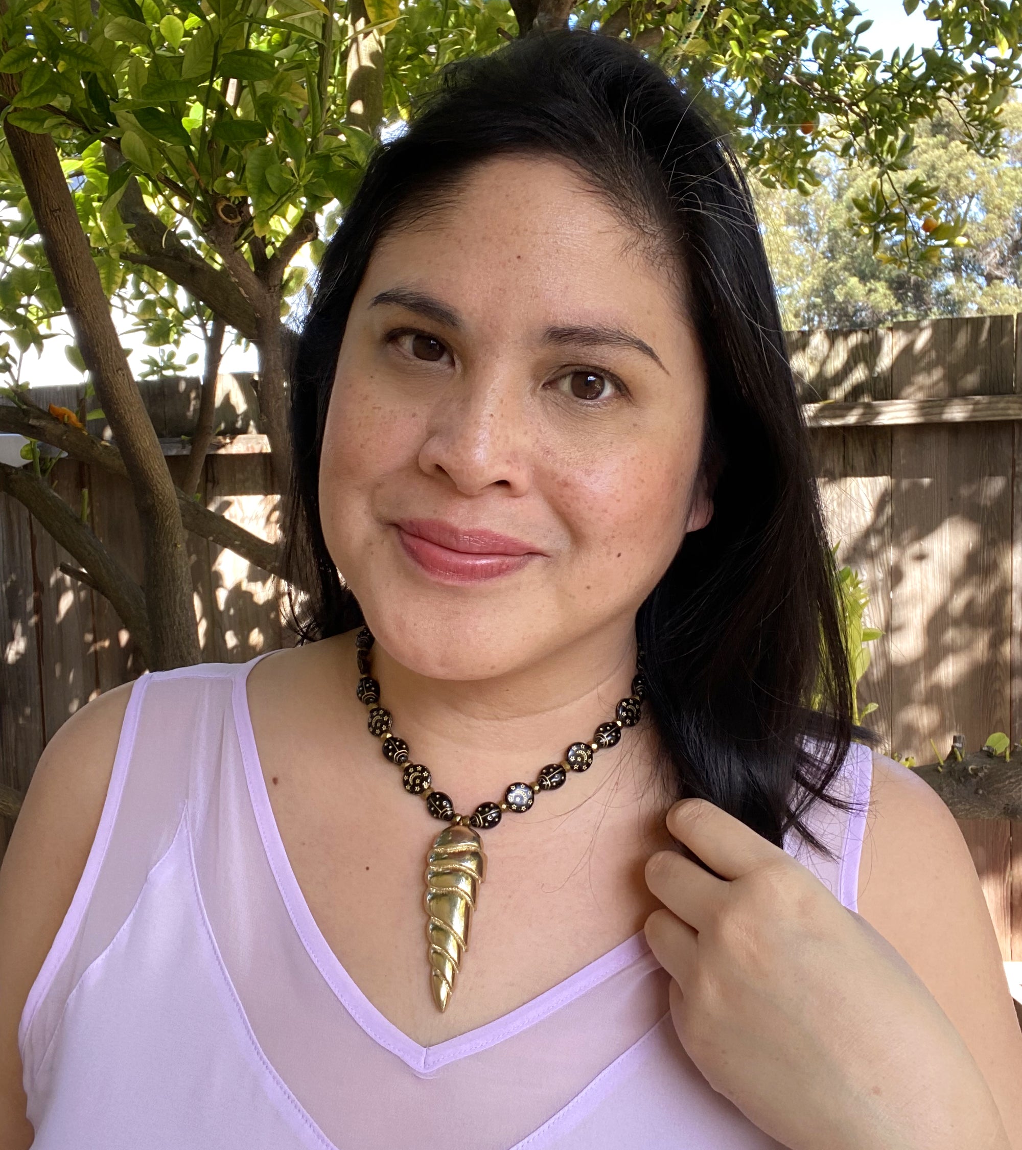 Jenny Dayco wearing golden spearhead necklace