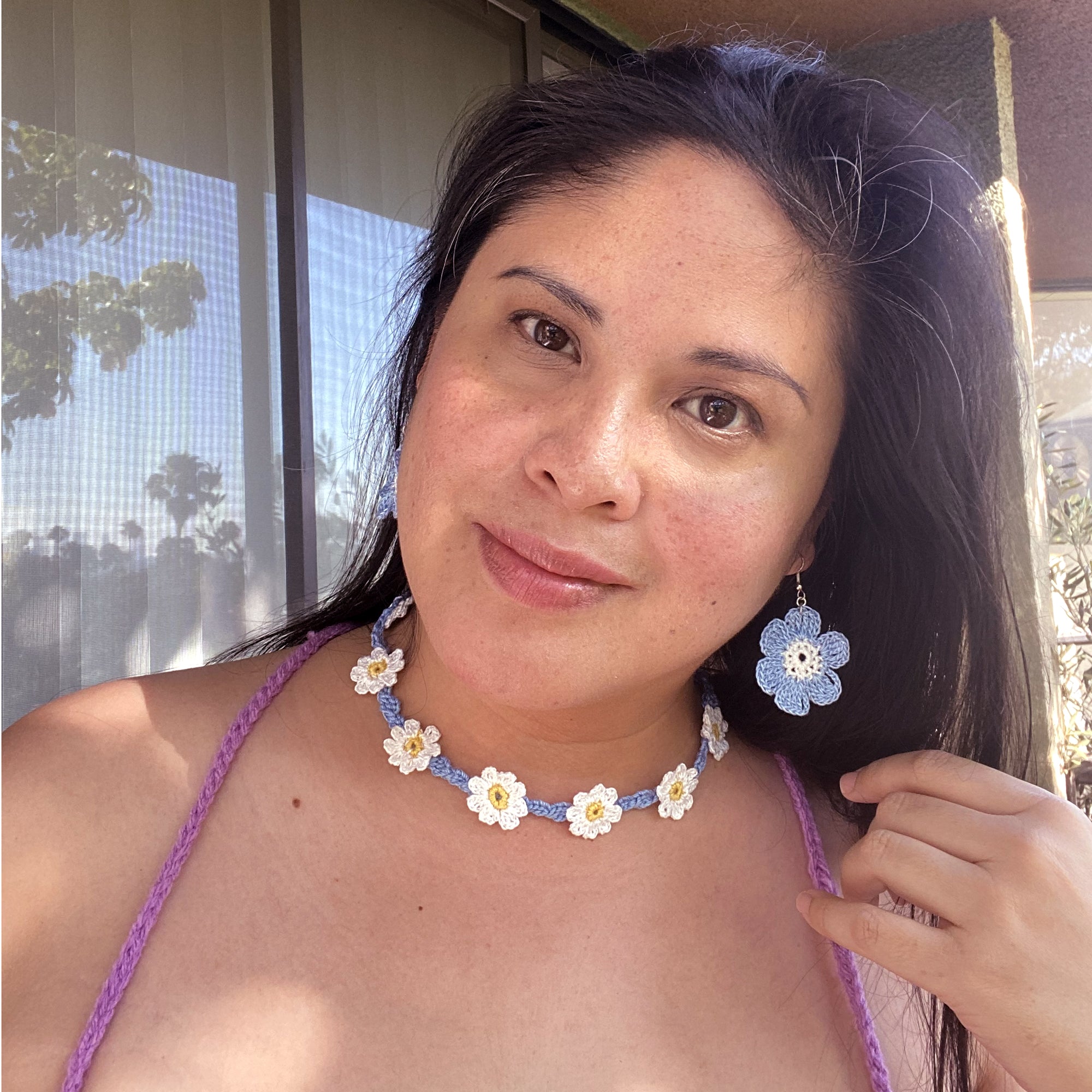 Jenny Dayco wearing a blue and white daisy crochet jewelry set