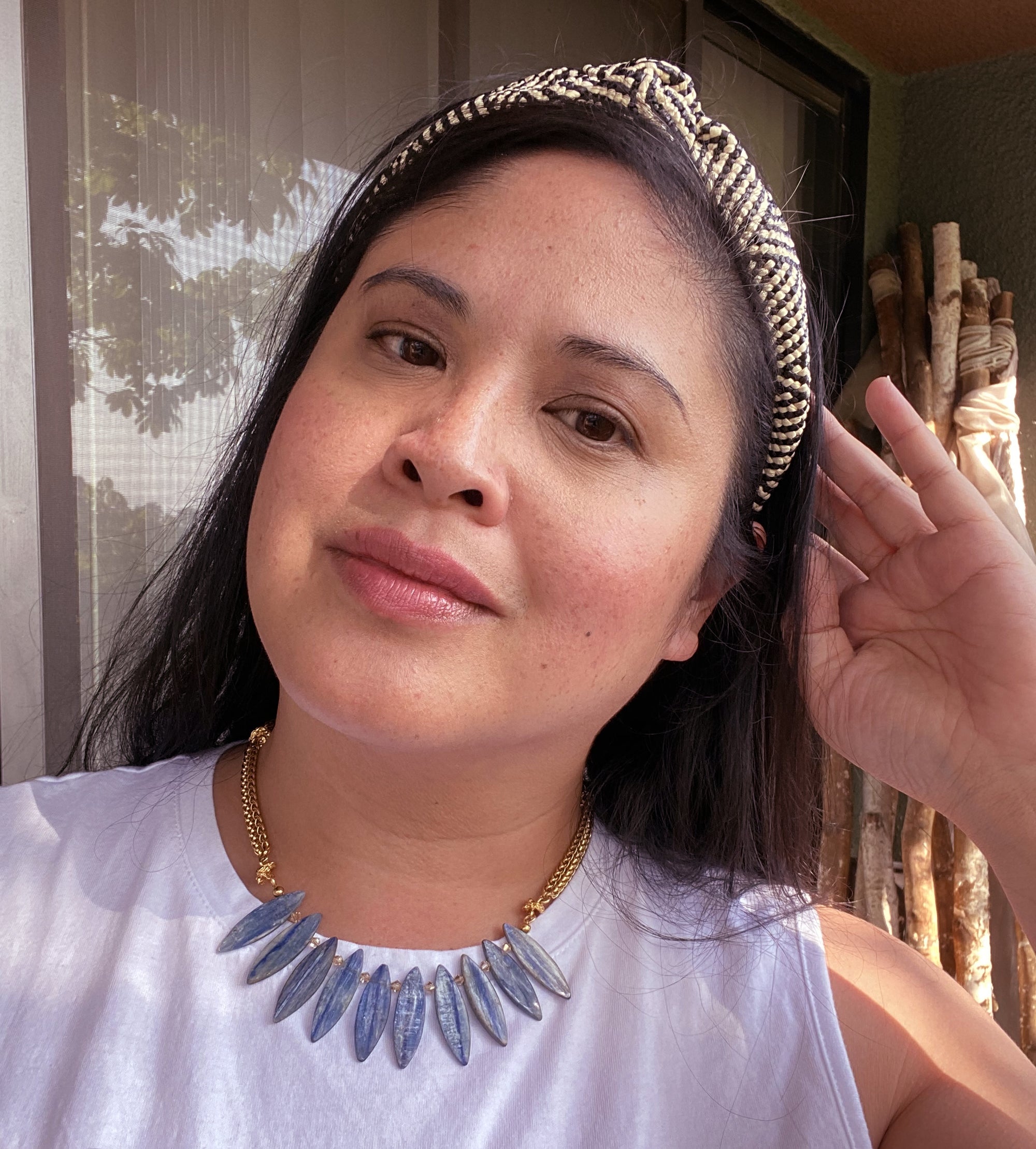Jenny Dayco wearing a blue kyanite surfboard necklace
