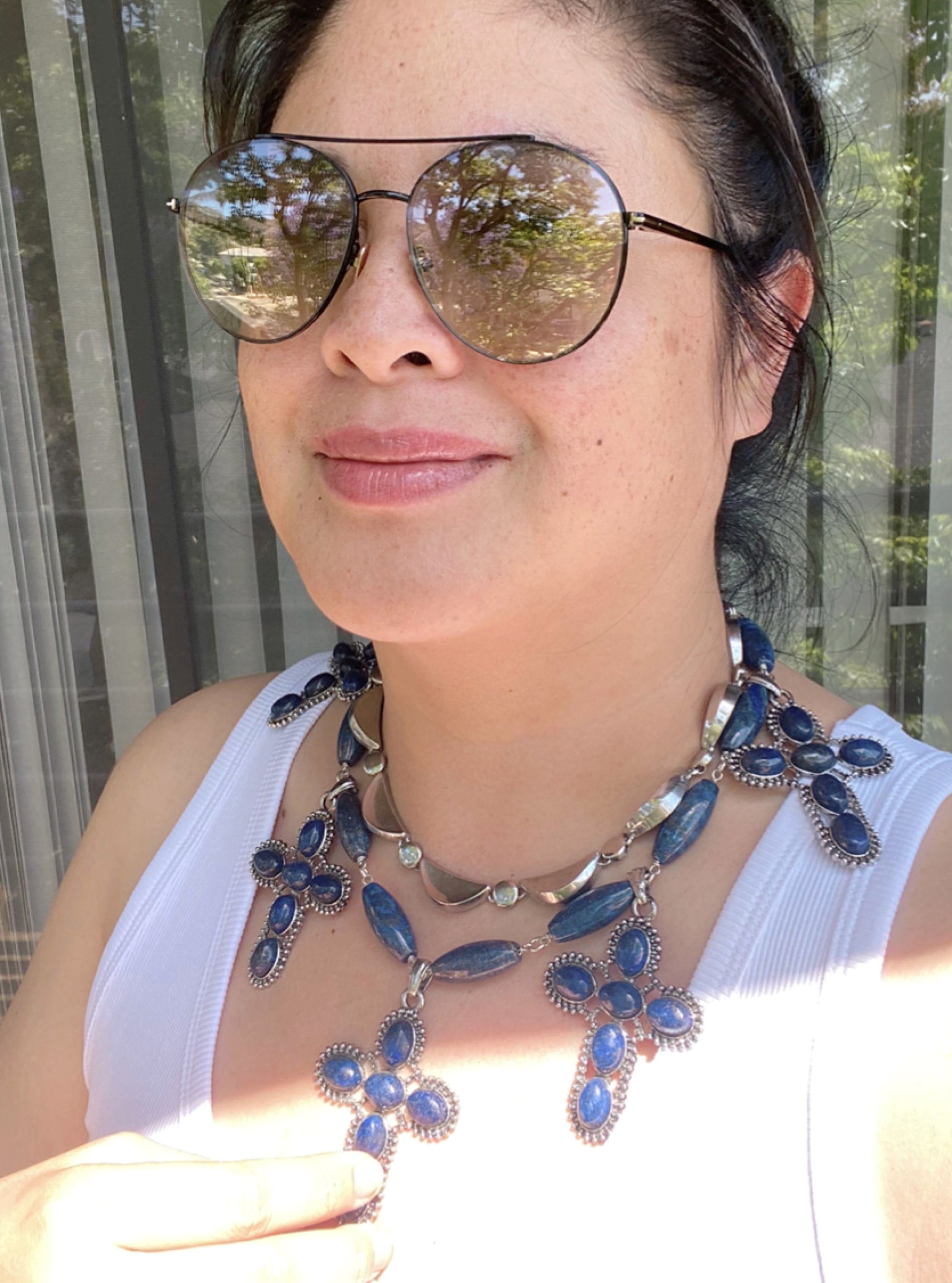 Jenny Dayco wearing a lapis lazuli cross necklace