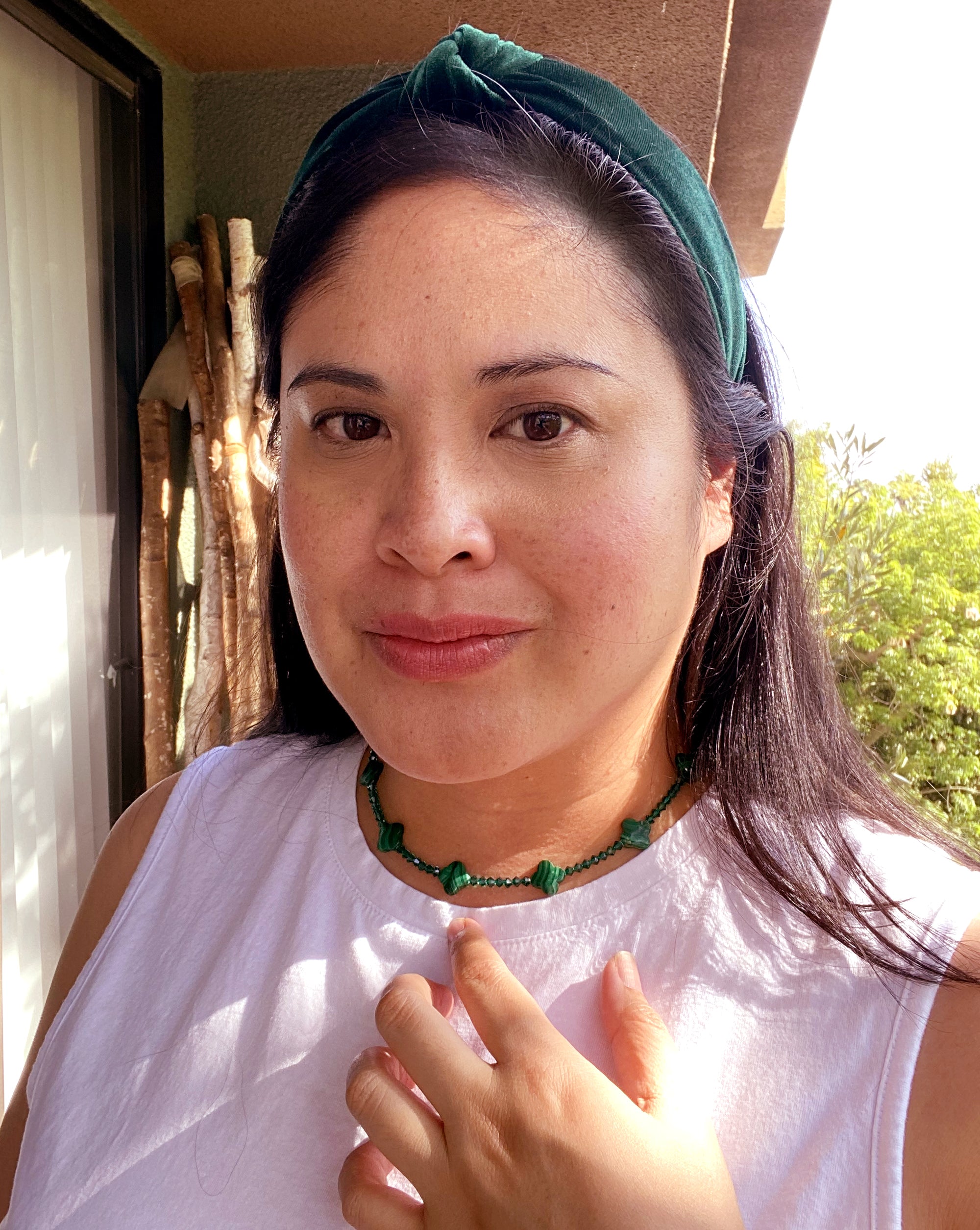 Jenny Dayco wearing a malachite clover and crystal necklace