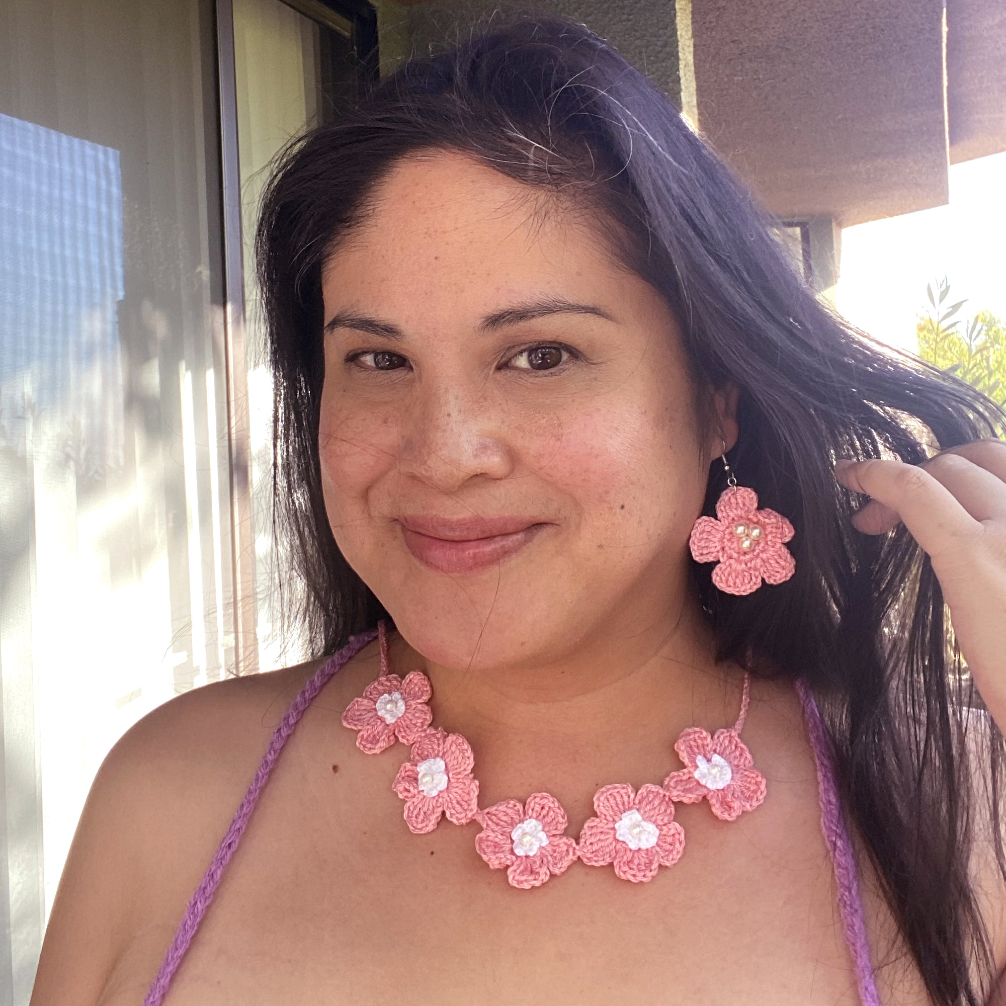 Jenny Dayco wearing a pink and white daisy crochet jewelry set
