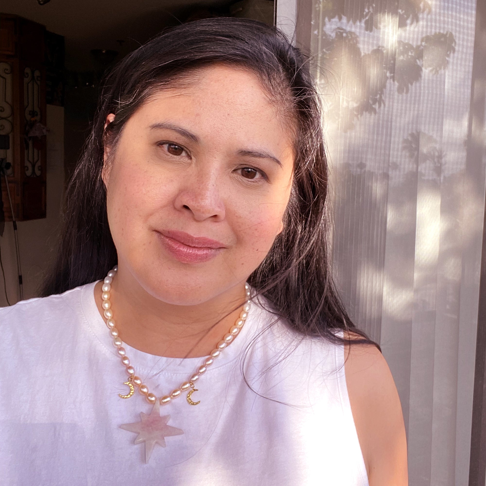Jenny Dayco wearing a rose quartz star and pearl necklace