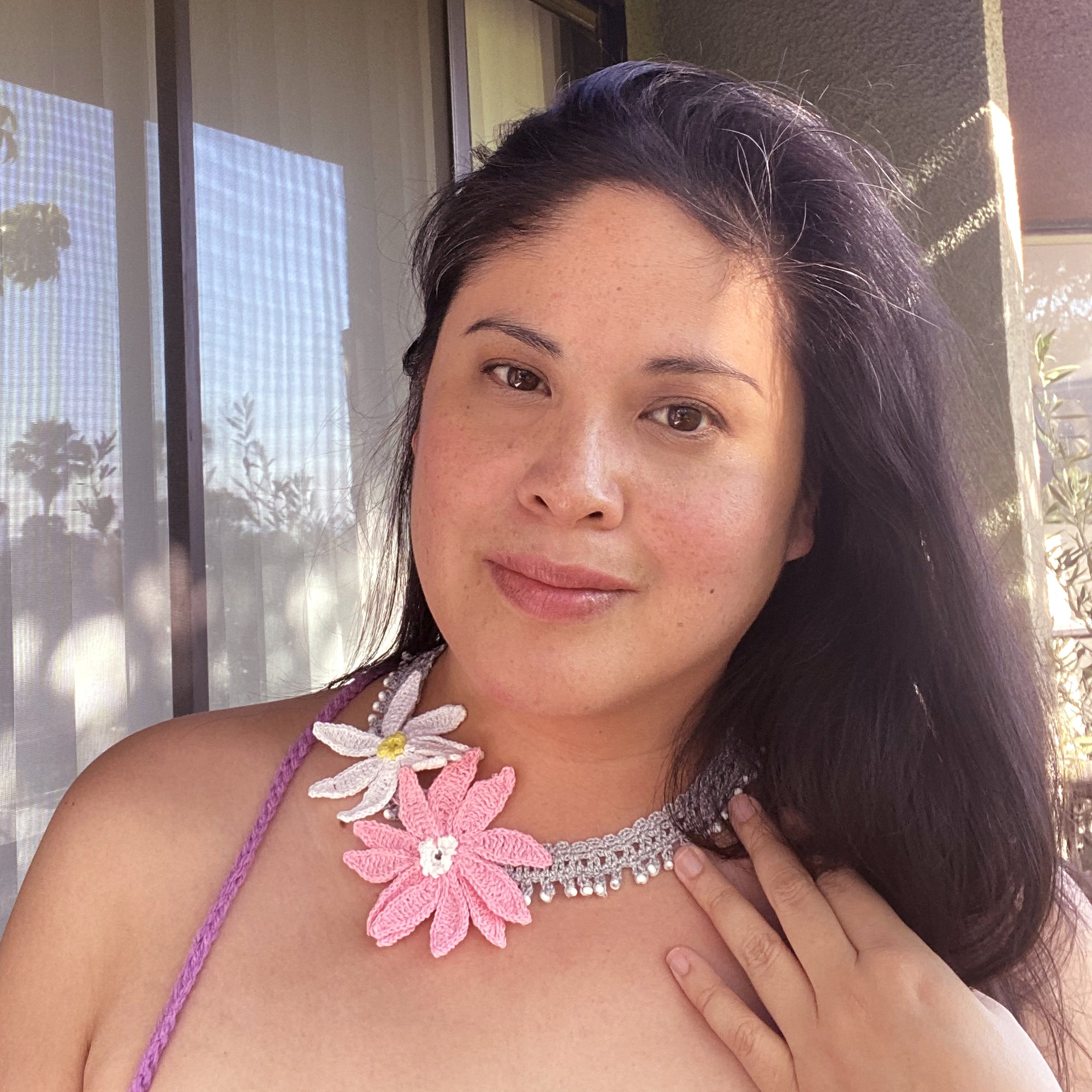 Jenny Dayco wearing a white and pink daisy crochet necklace