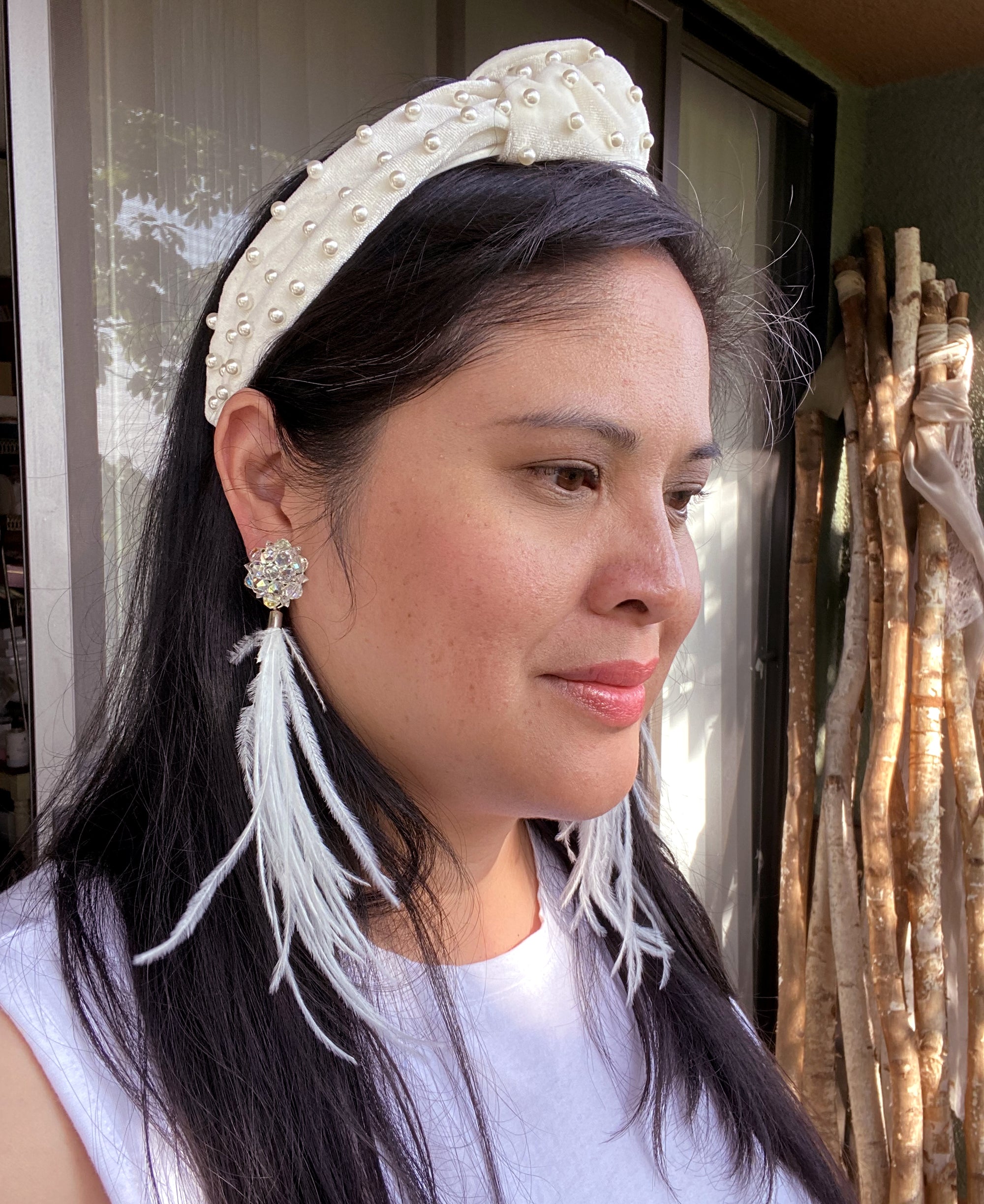 Jenny Dayco wearing iridescent crystal feather earrings