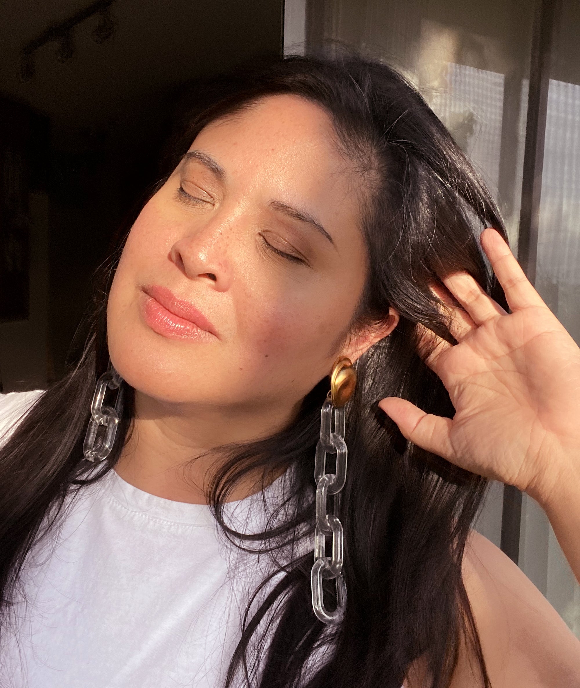 Jenny Dayco wearing matte gold and clear chain earrings