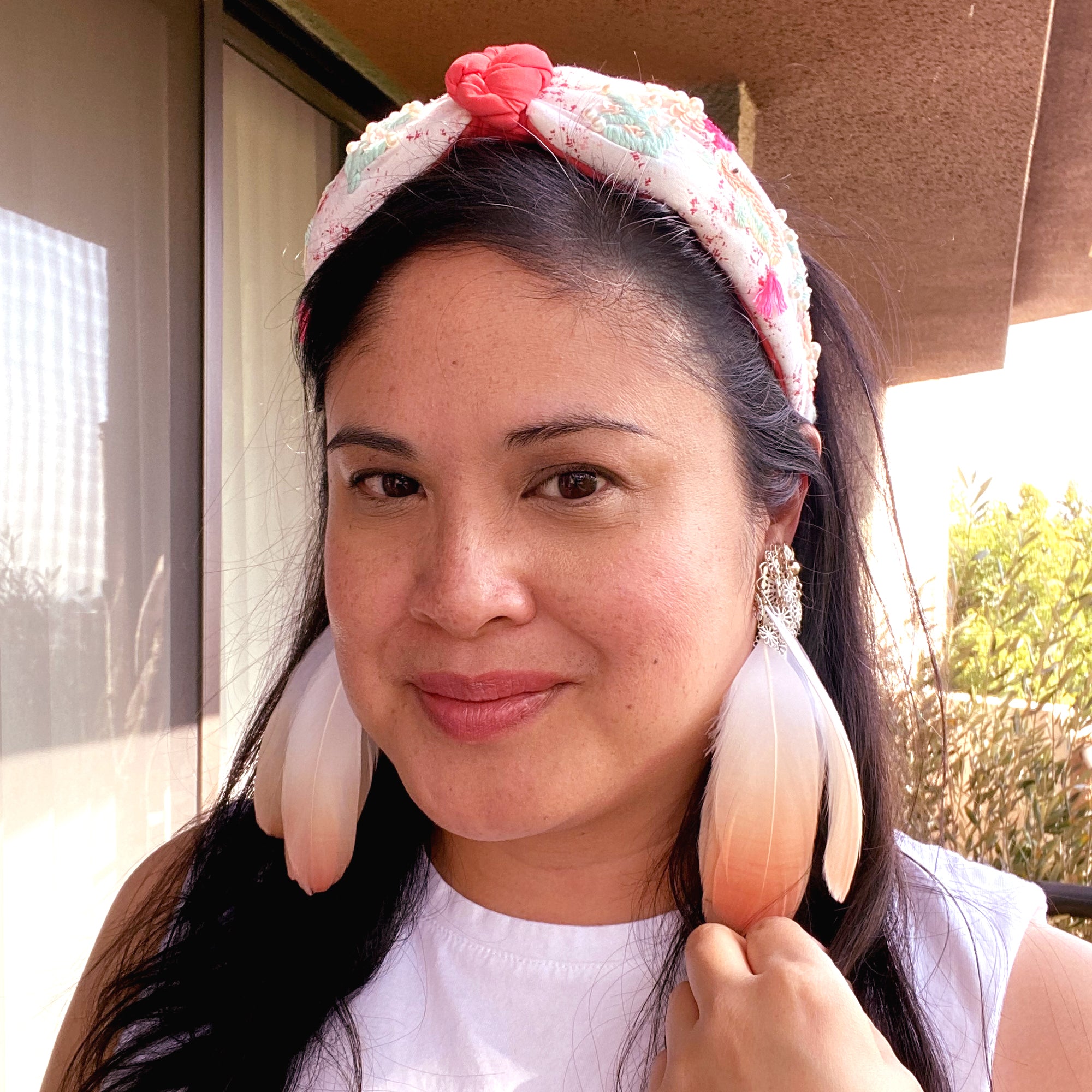 Jenny Dayco wearing peach feather and vintage white filigree flower clip on earrings