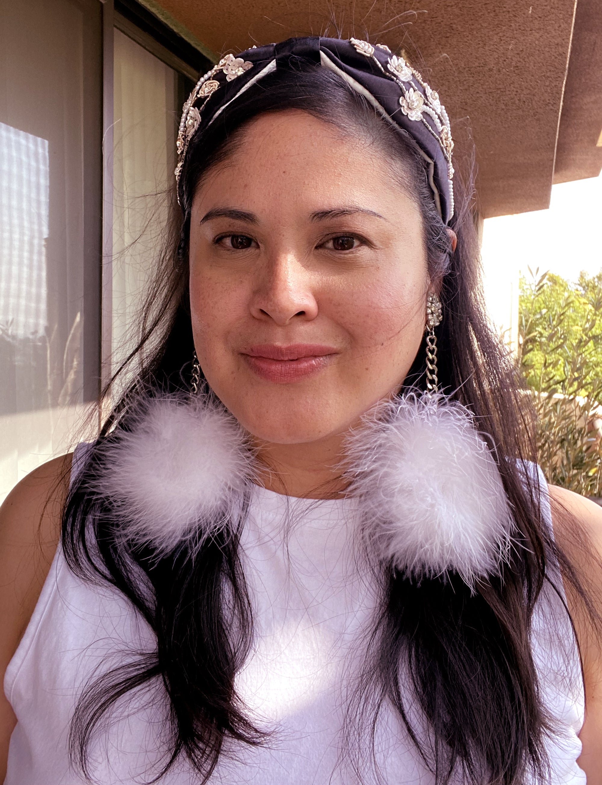 Jenny Dayco wearing rhinestone feather donut earrings