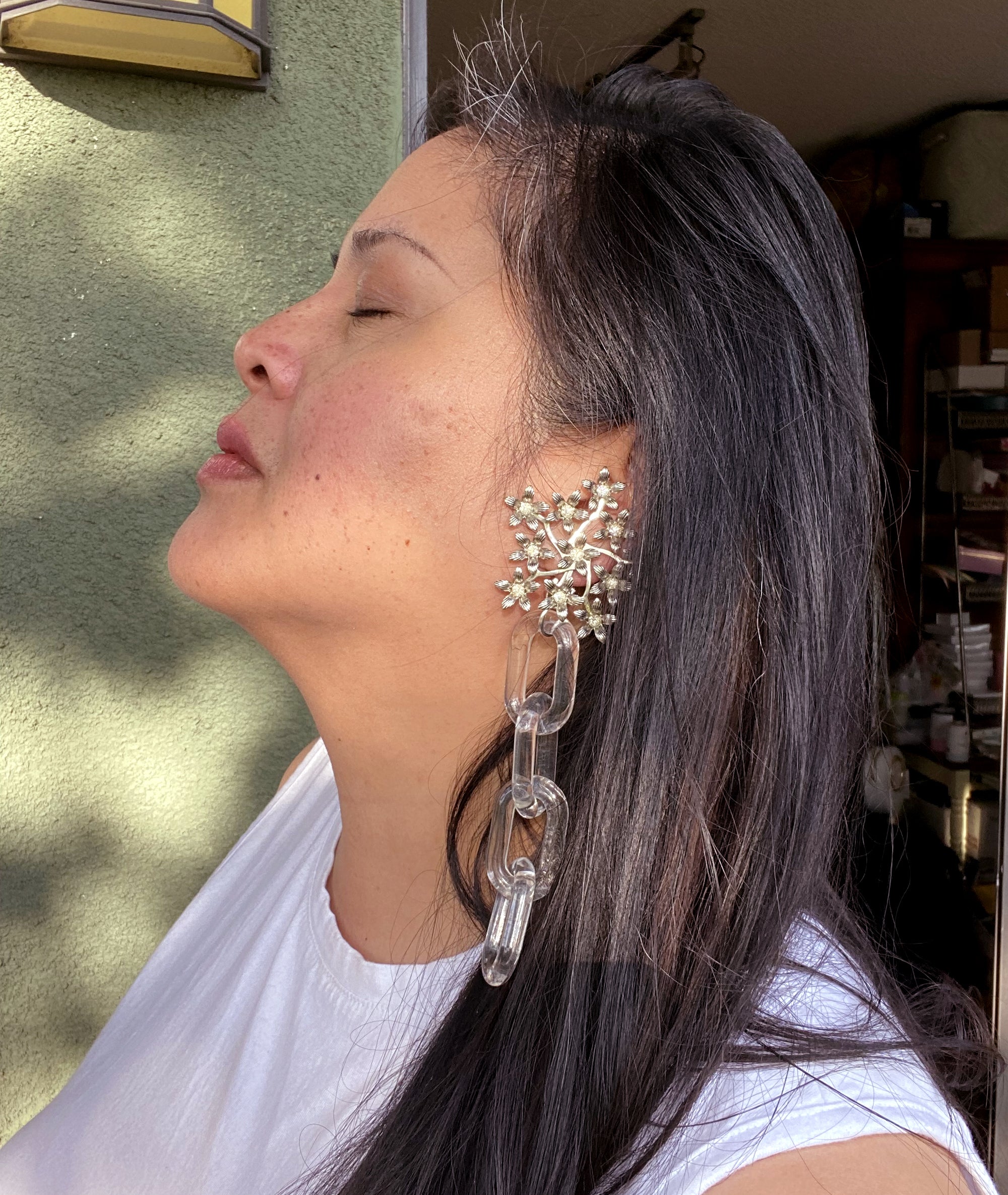 Jenny Dayco wearing silver rhinestone flower and clear chain earrings